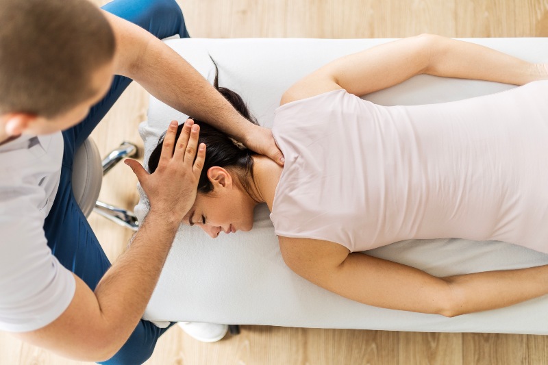 Person receiving a head massage on a table in a clinic in Clayton Heights, Surrey, Langley